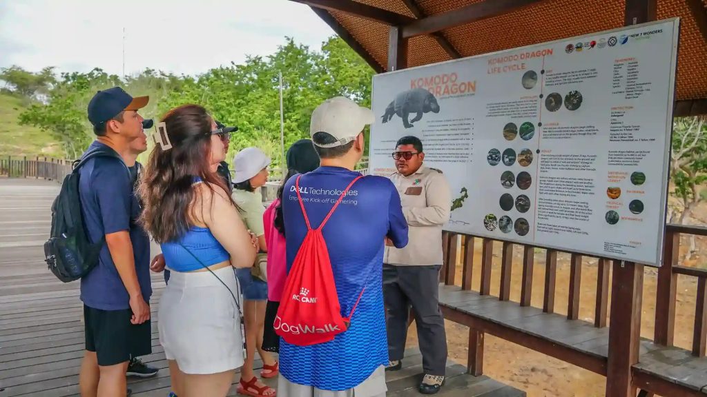 A ranger briefing visitors at a park information board