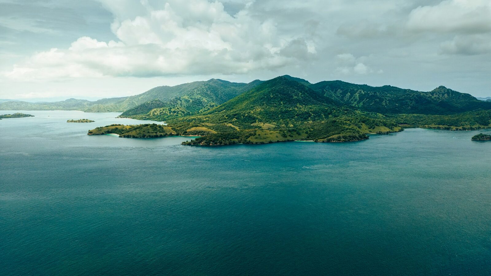 Green hills and sheltered island coastline near Labuan Bajo, the gateway to Komodo National Park, photographed from the air