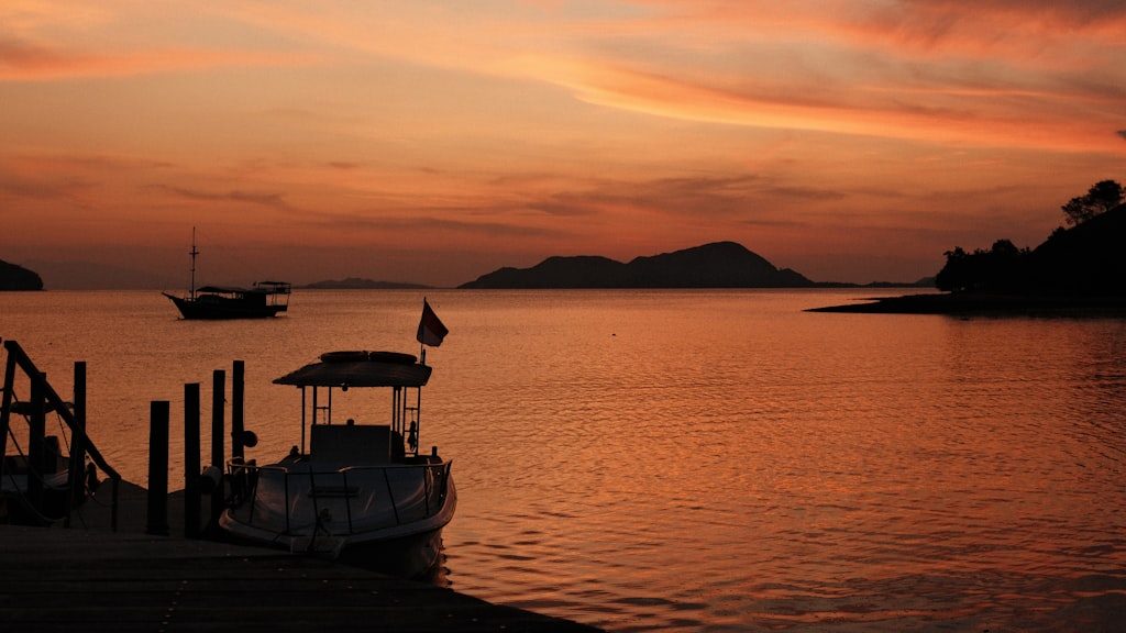 A boat sitting on top of a body of water under a cloudy sky