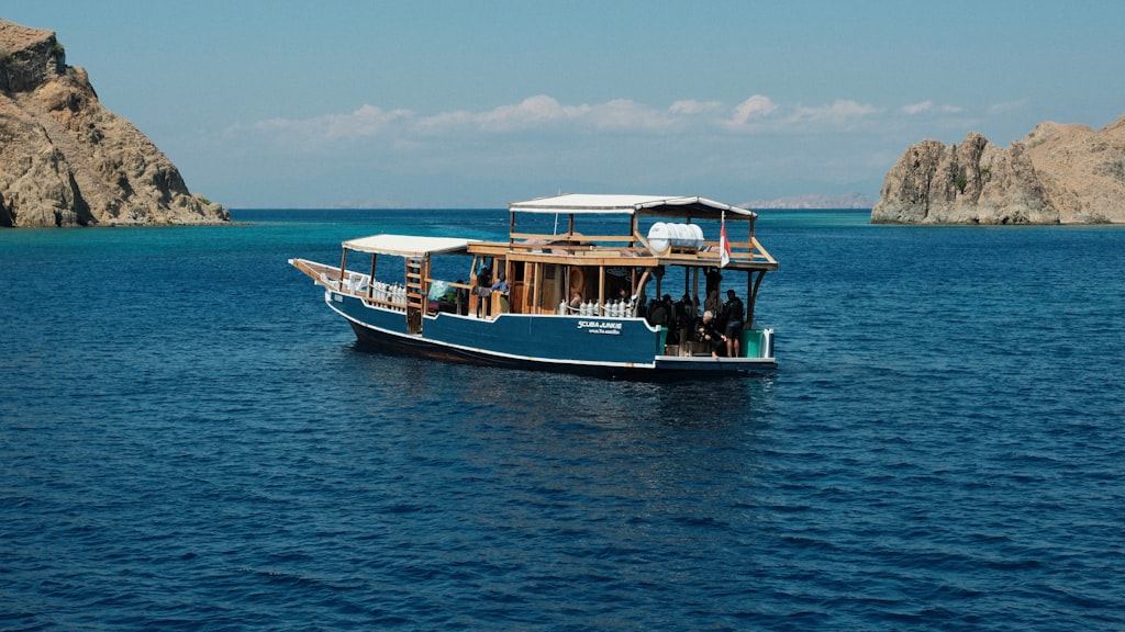 A boat floating on top of a large body of water with hills on the horizon