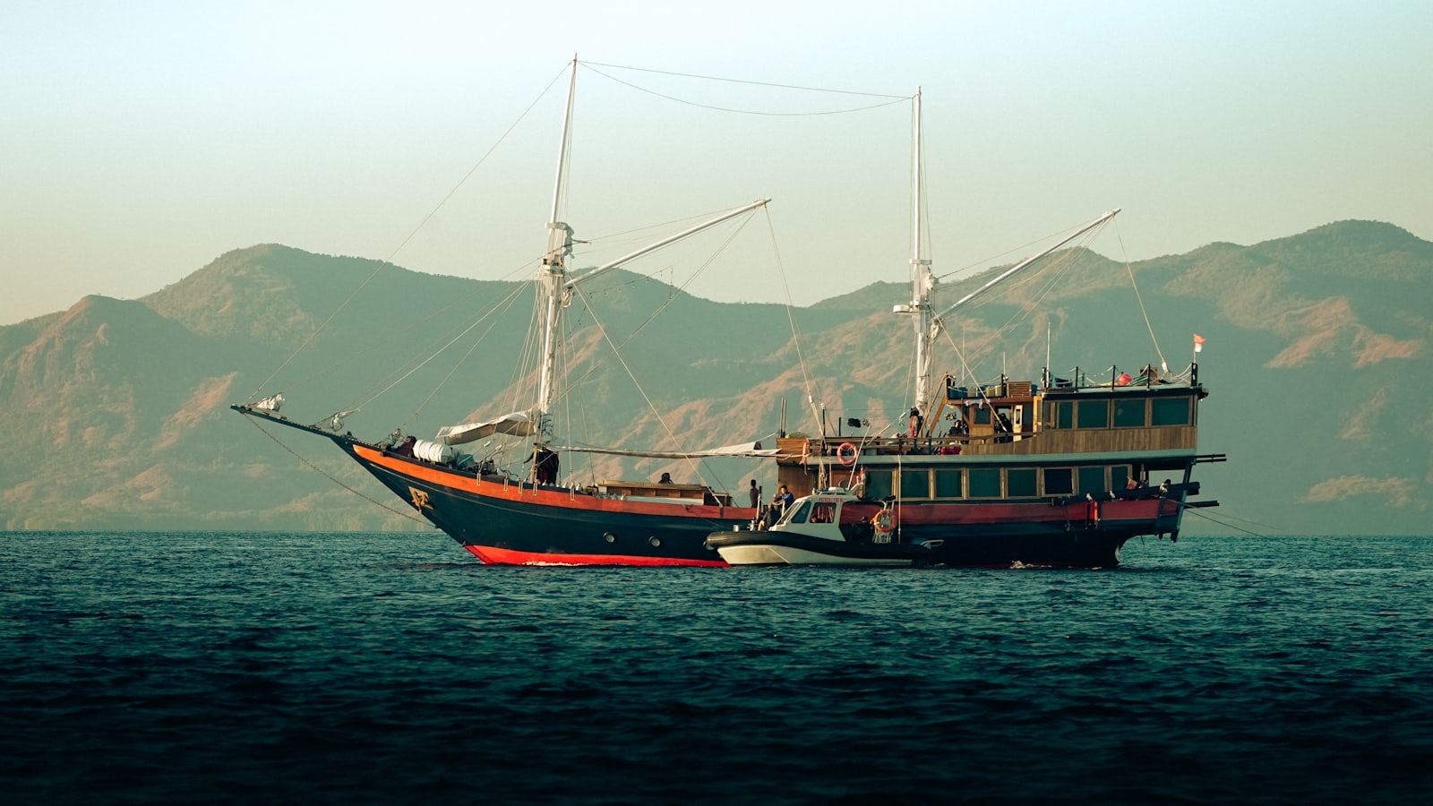 A boat floating on top of a large body of water under an open sky