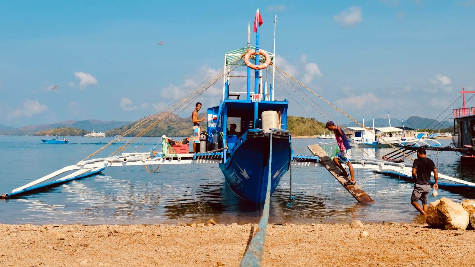 A blue and white boat sitting on top of a body of water