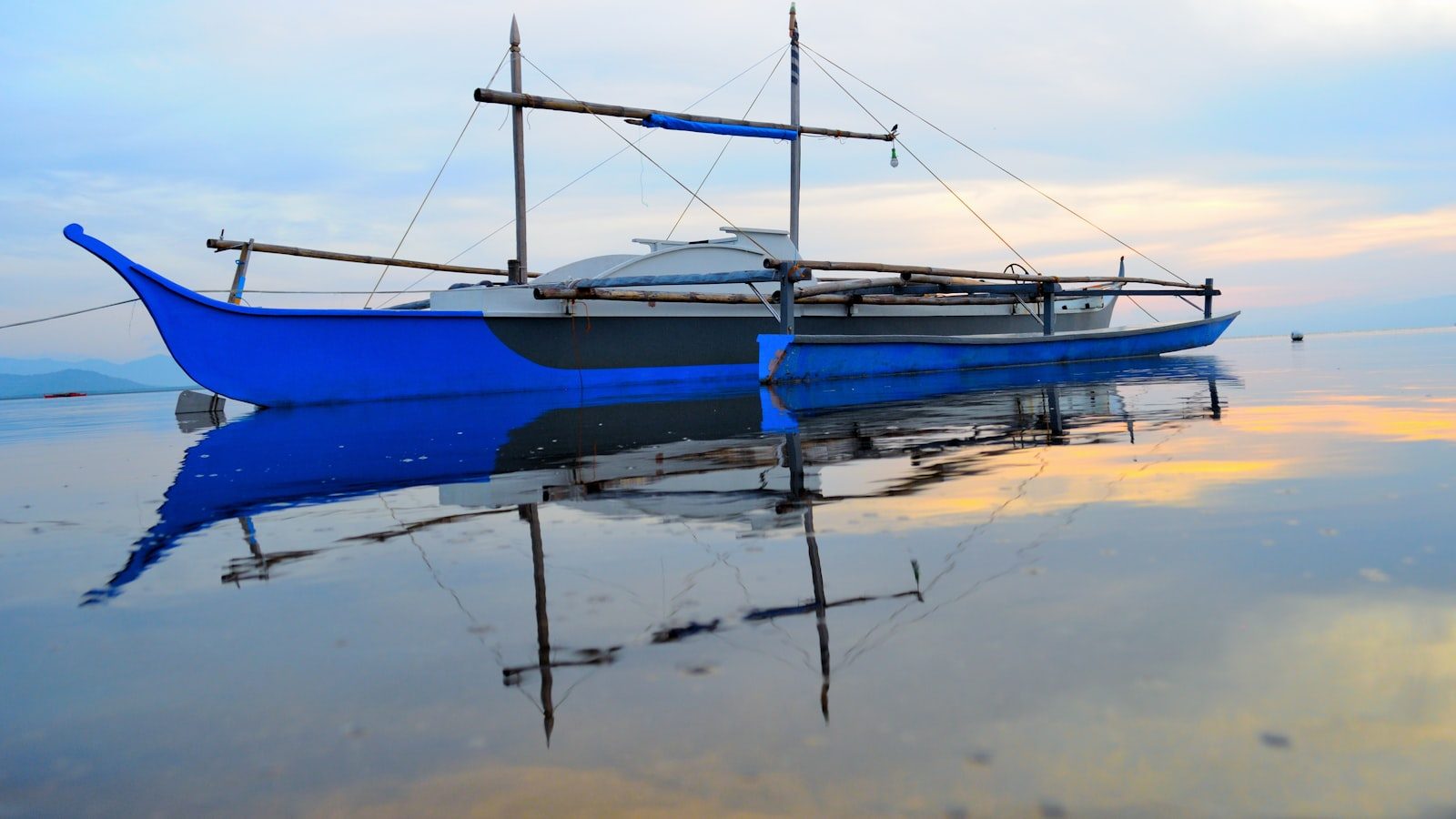 A blue boat floating on top of a body of water