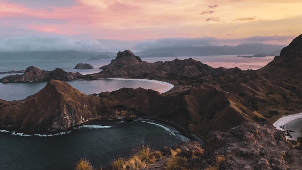 Body of water between mountains during sunset