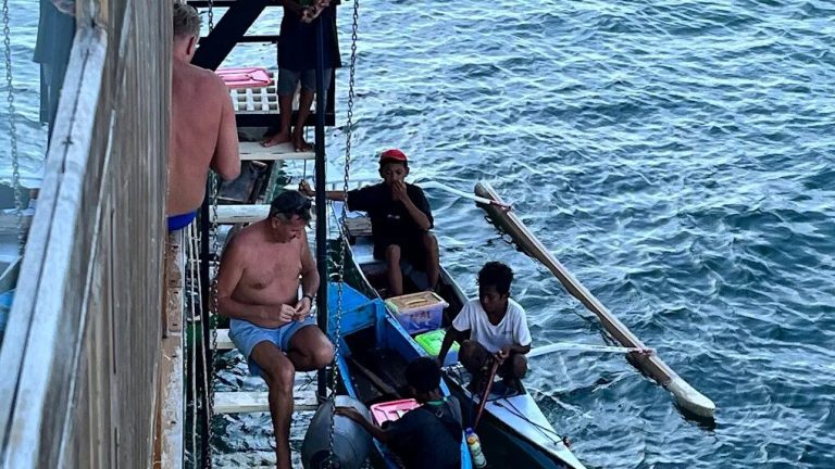 Passengers on the side deck of a boat in open water