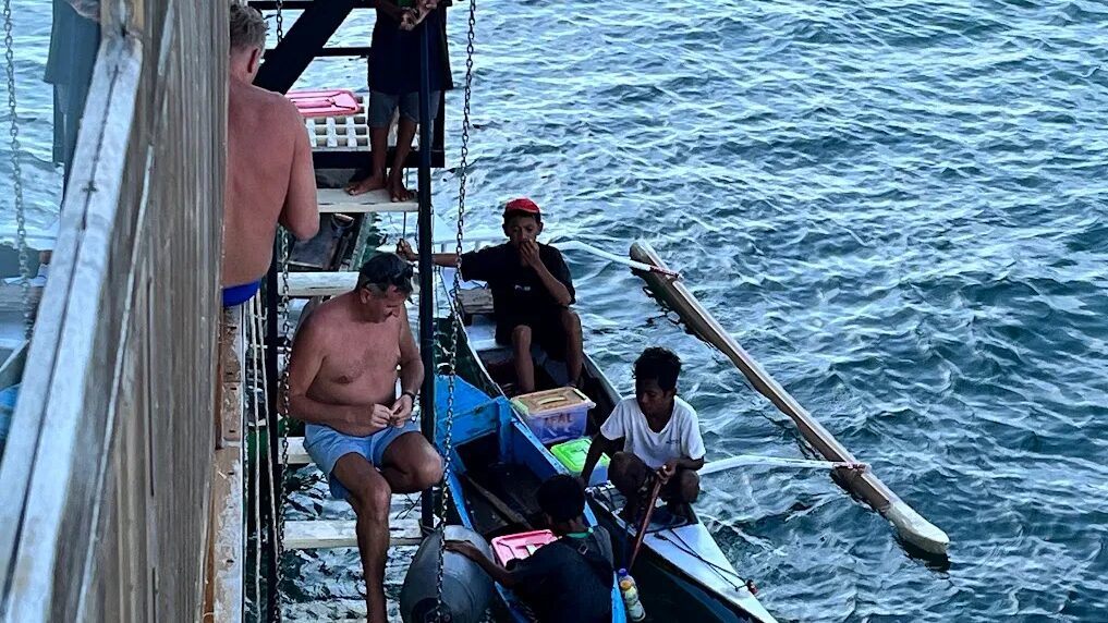 Passengers on the side deck of a boat in open water