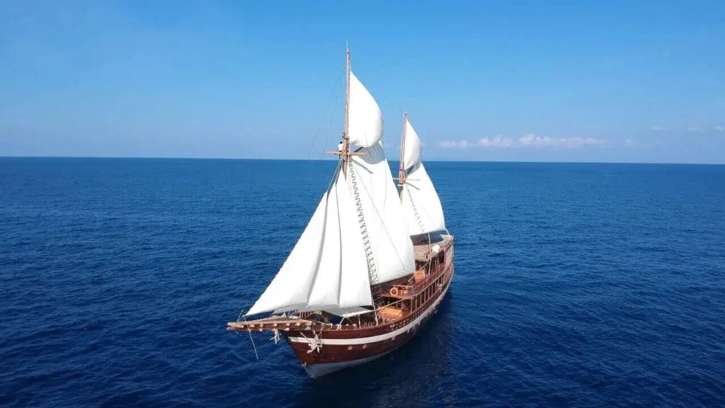 A private phinisi under sail on open water