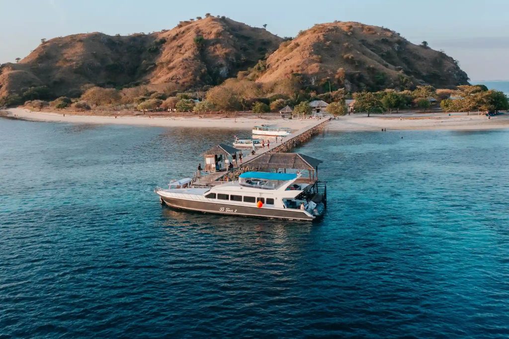 A day-trip boat alongside the jetty off a small green island